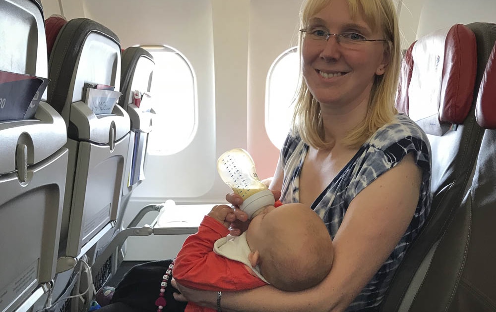 Baby trinkt Flasche im Flugzeug beim Start